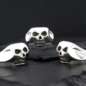 Three skull-shaped objects with black and white patterns on a black surface.