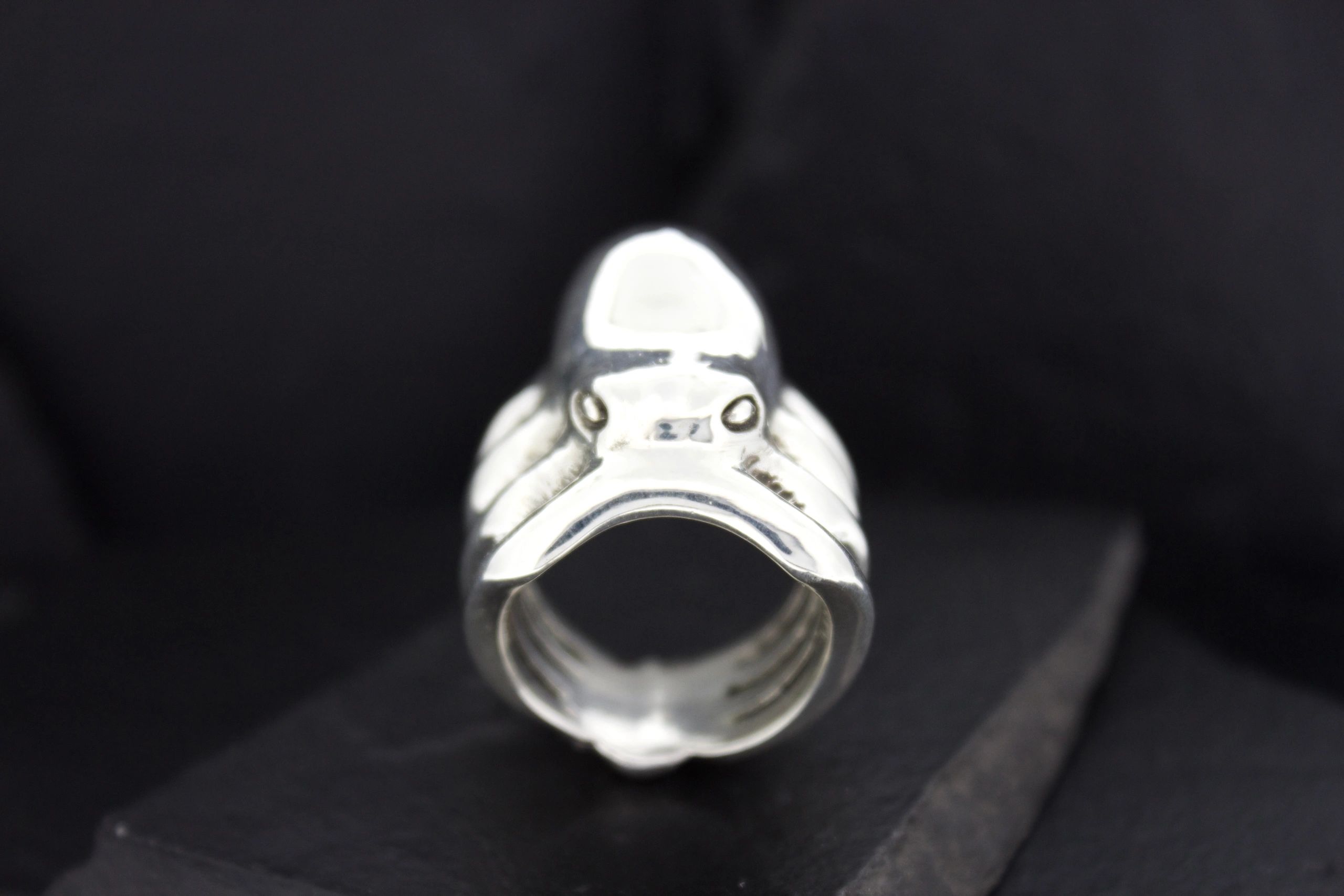 Silver ring shaped like a frog with detailed eyes and limbs.