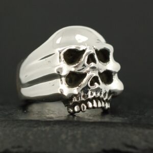Silver ring with two stacked skull designs.