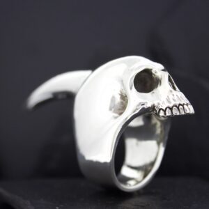 A silver ring shaped like a detailed human skull.