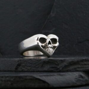 A silver ring shaped like a skull with heart-like features.