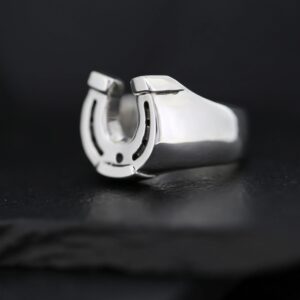 A silver ring featuring a horseshoe design on a black background.