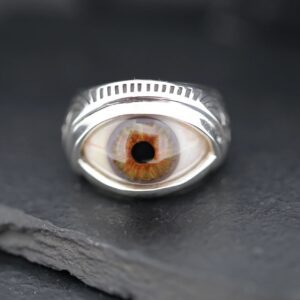 A silver ring featuring a detailed, realistic eye design.