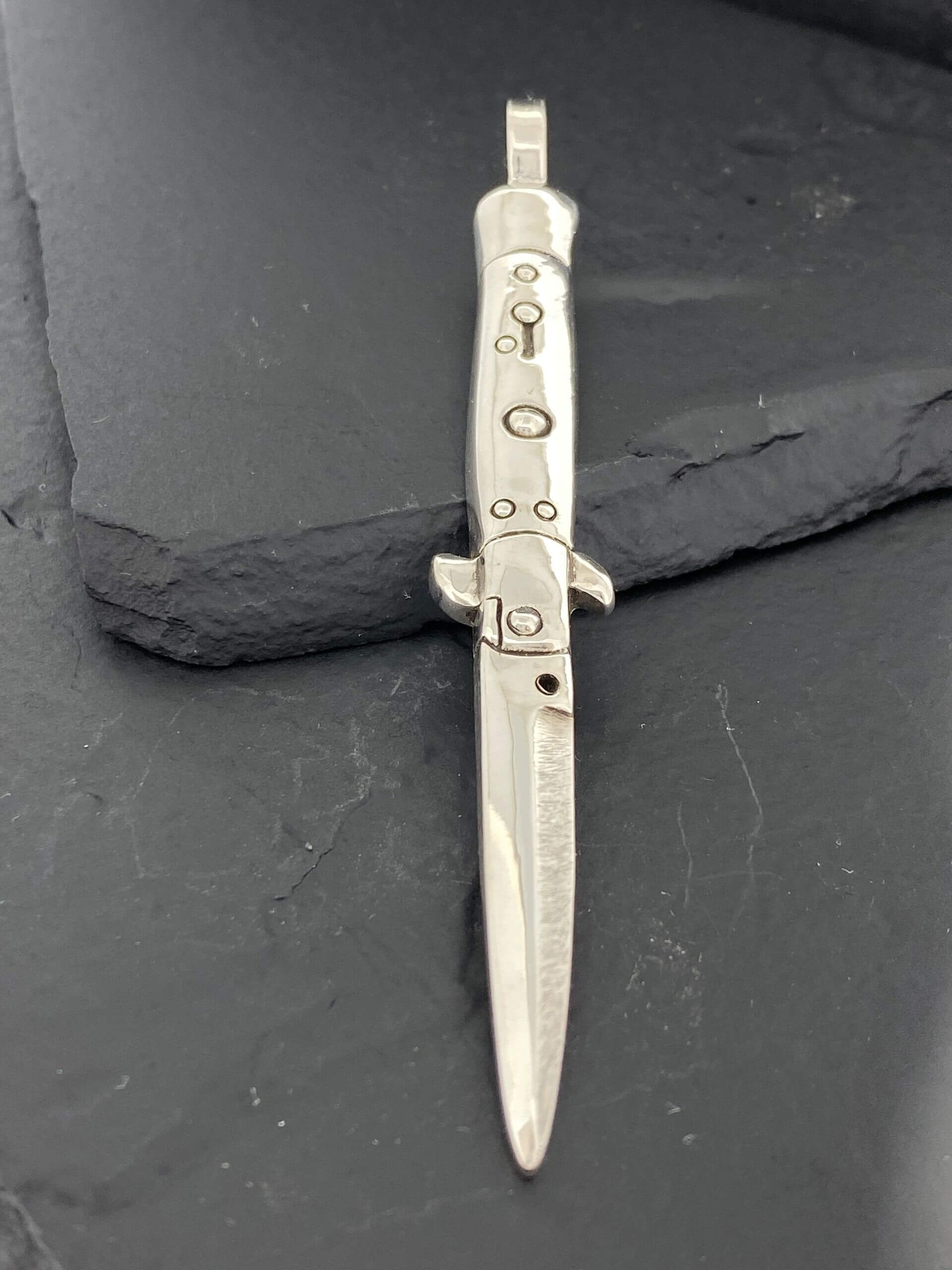 Vintage switchblade knife with a metallic handle and blade.