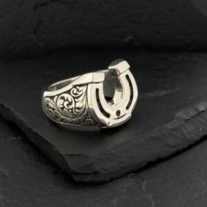 Intricately designed silver ring with a horseshoe motif.