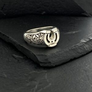 Silver ring with Arabic calligraphy on dark stone background.