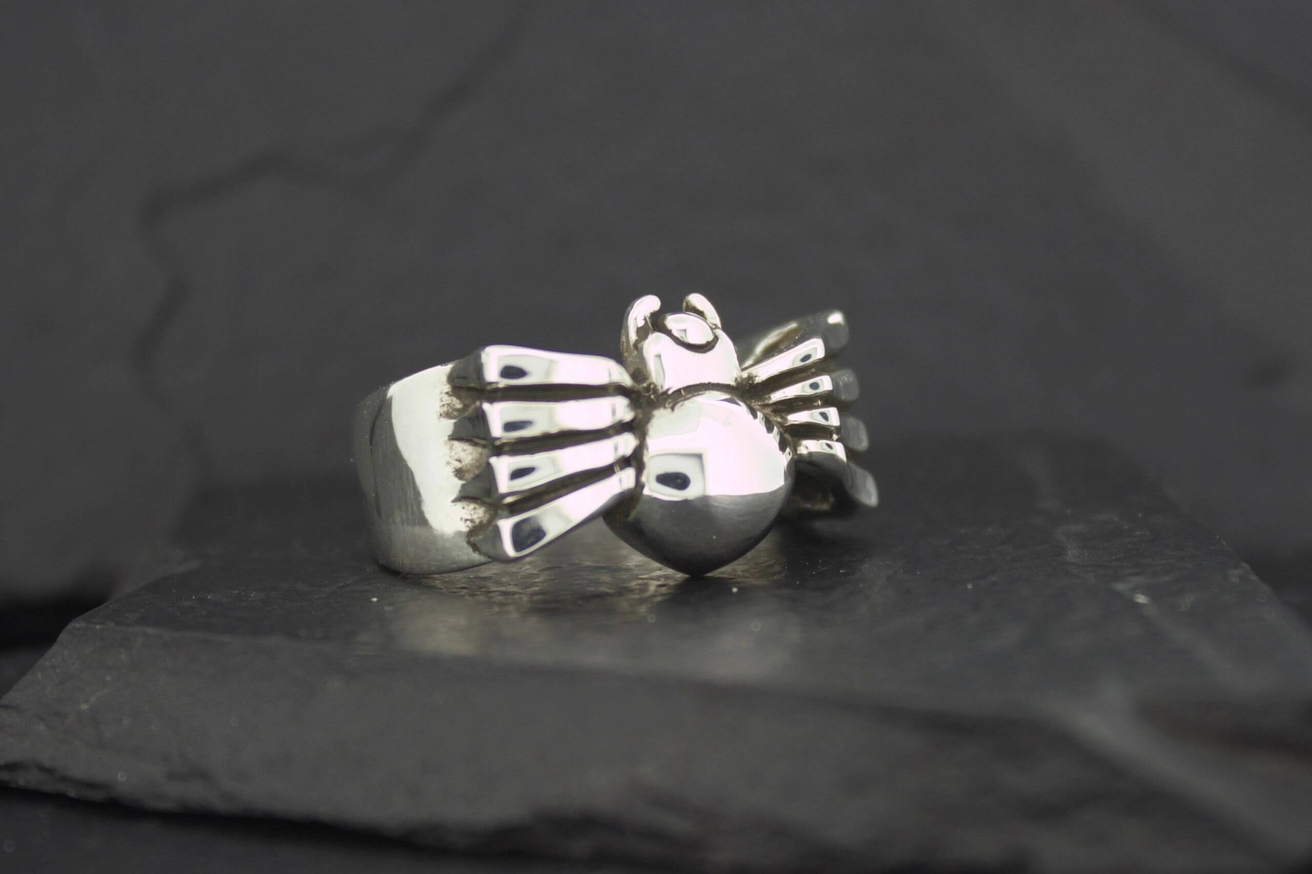 A silver ring featuring a detailed spider design.