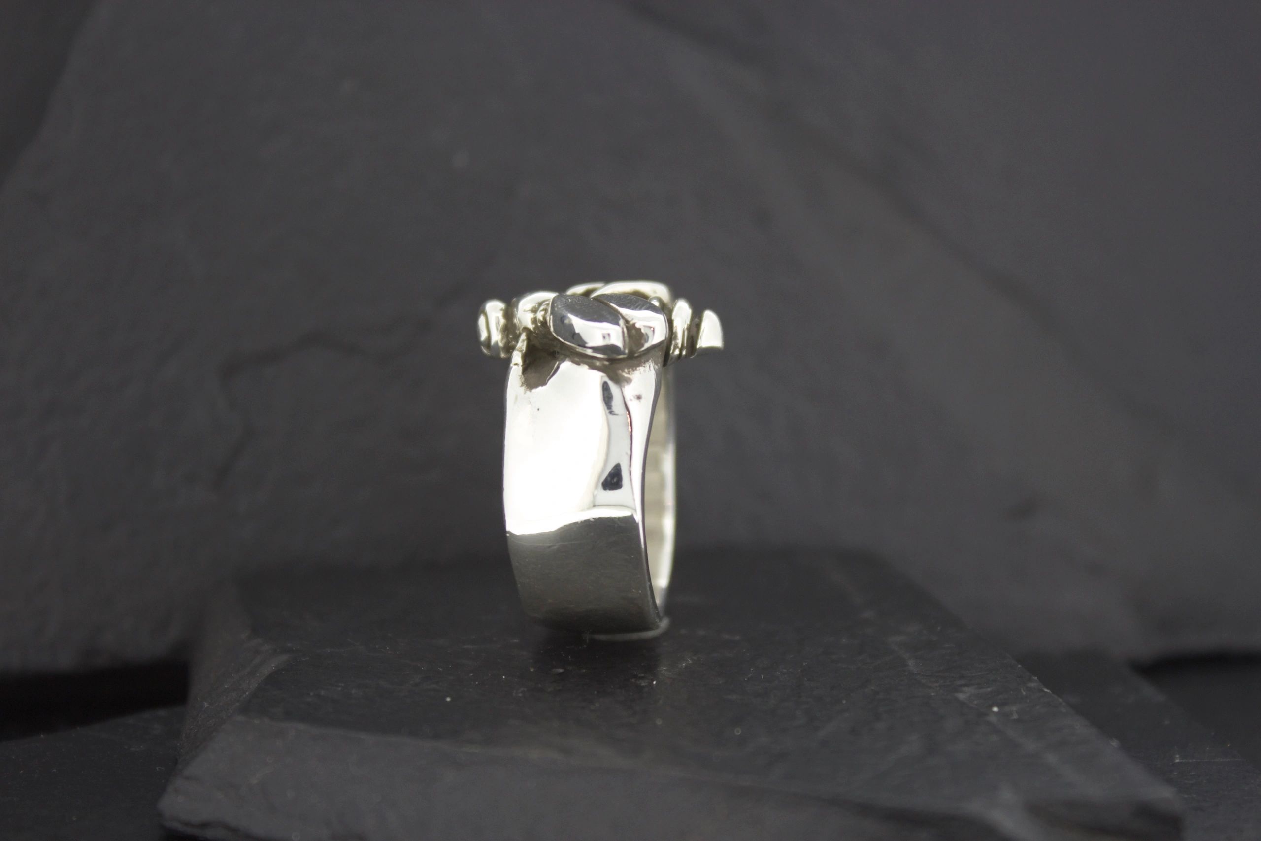 Close-up of a silver ring with a square gemstone.