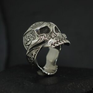 Intricately designed skull-shaped ring with detailed carvings.