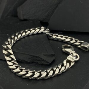 Sleek silver chain bracelet on black background.