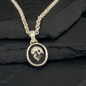 Silver pendant necklace with a skull and crossbones design.