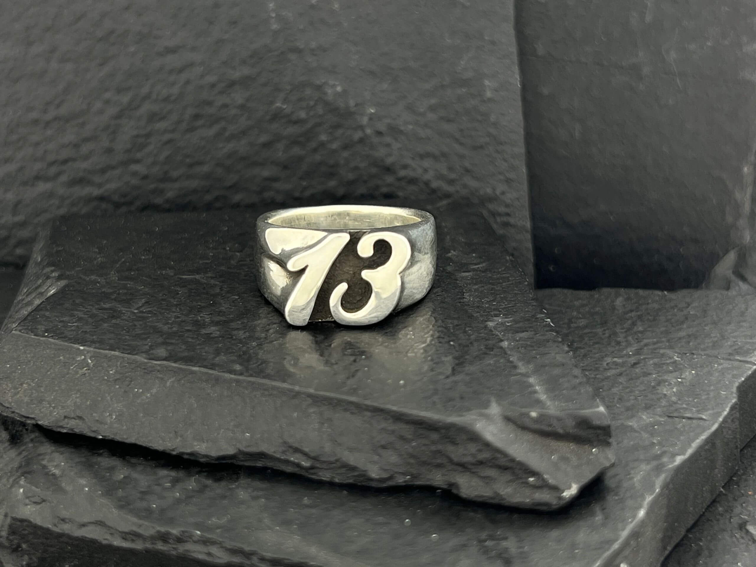 Silver ring with the number 73 engraved on it.