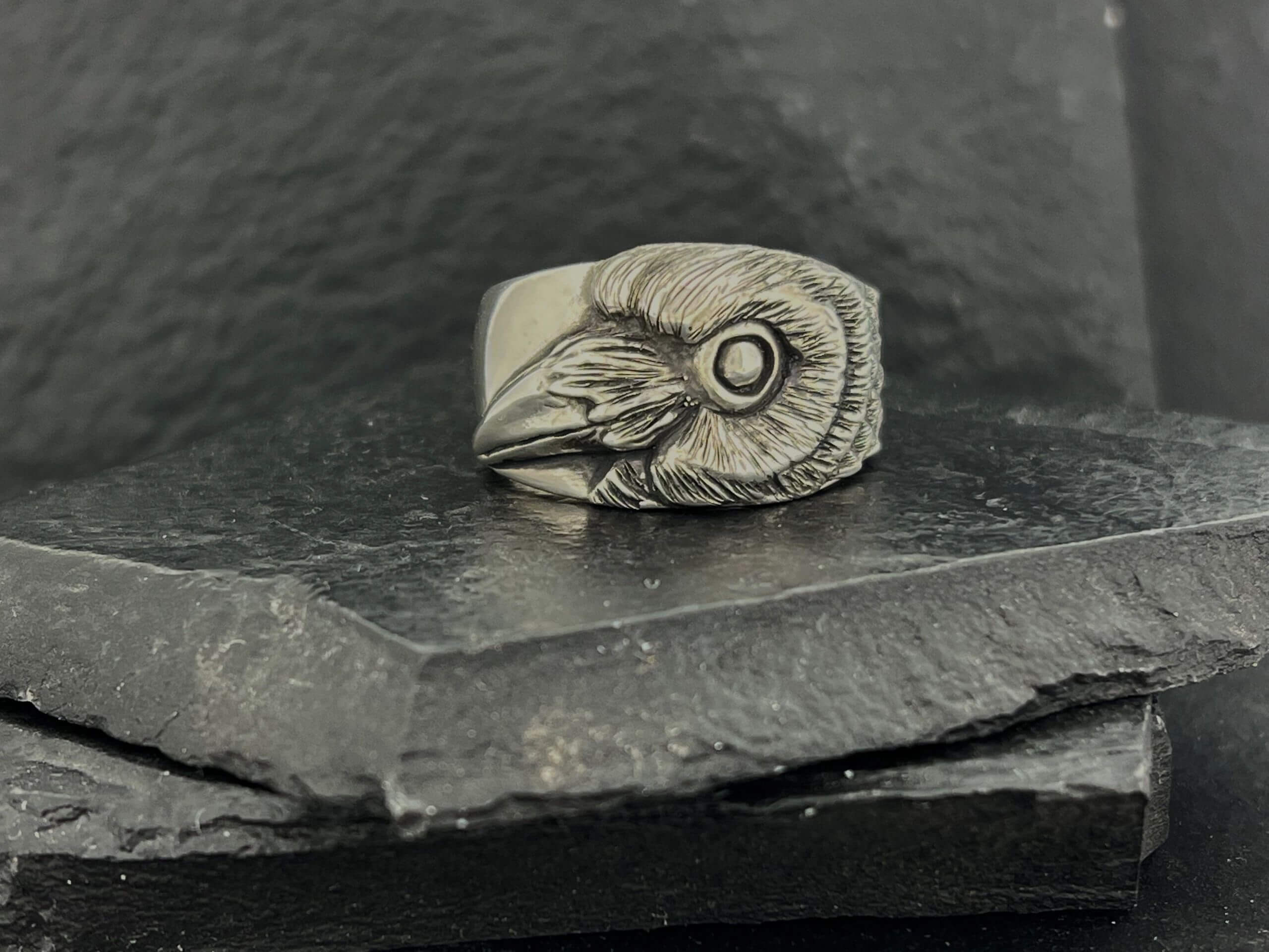 A silver ring featuring a detailed raven's head design.