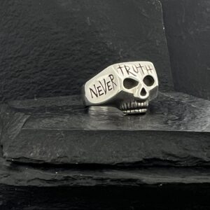 Silver skull ring engraved with 'NEVER TRUST'.