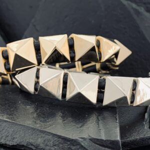 Close-up of a bracelet with pyramid-shaped metallic studs.