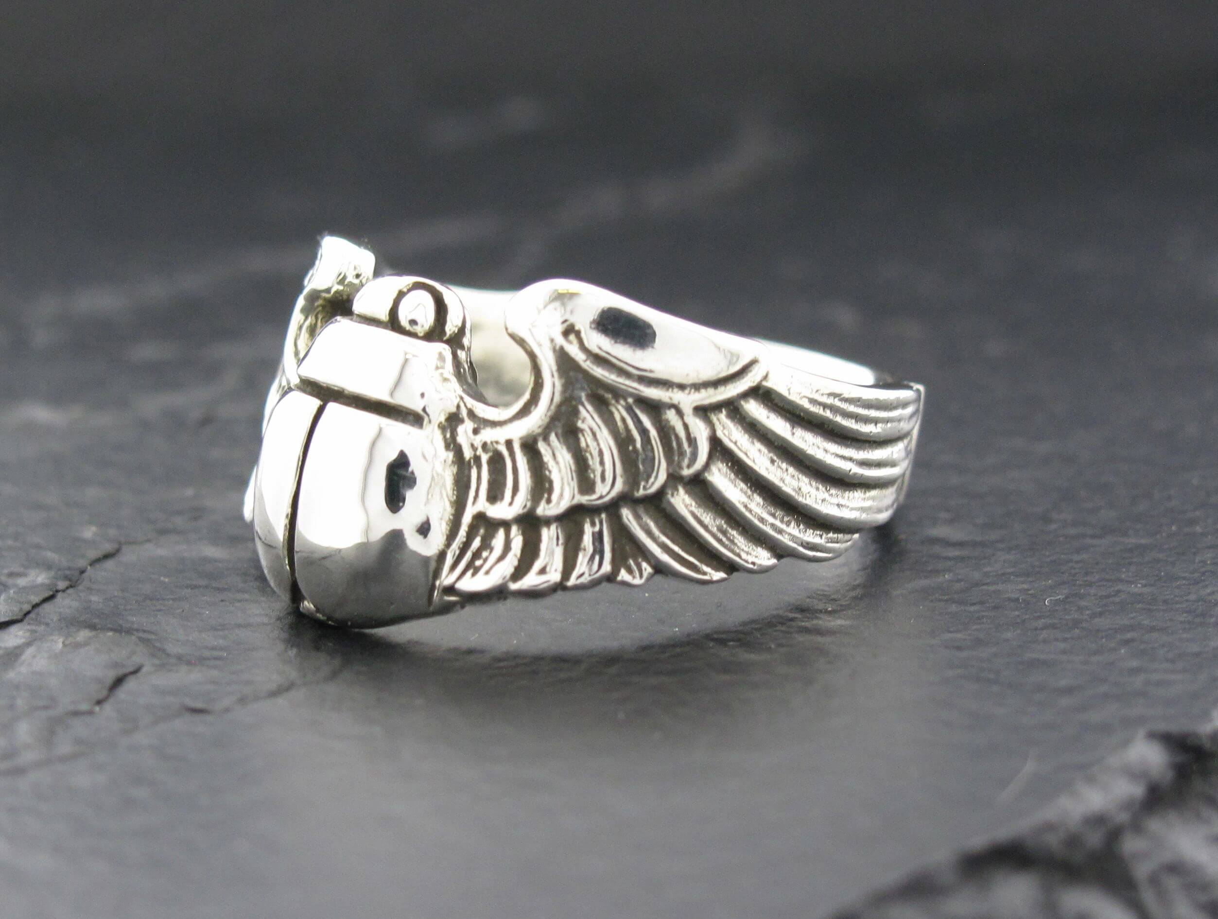 Silver ring with an intricate wing design.
