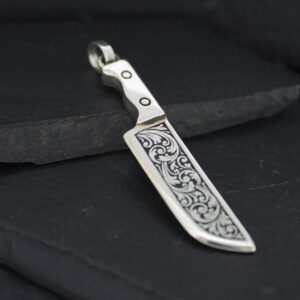 Intricately designed metal pendant resembling a small sword or blade.