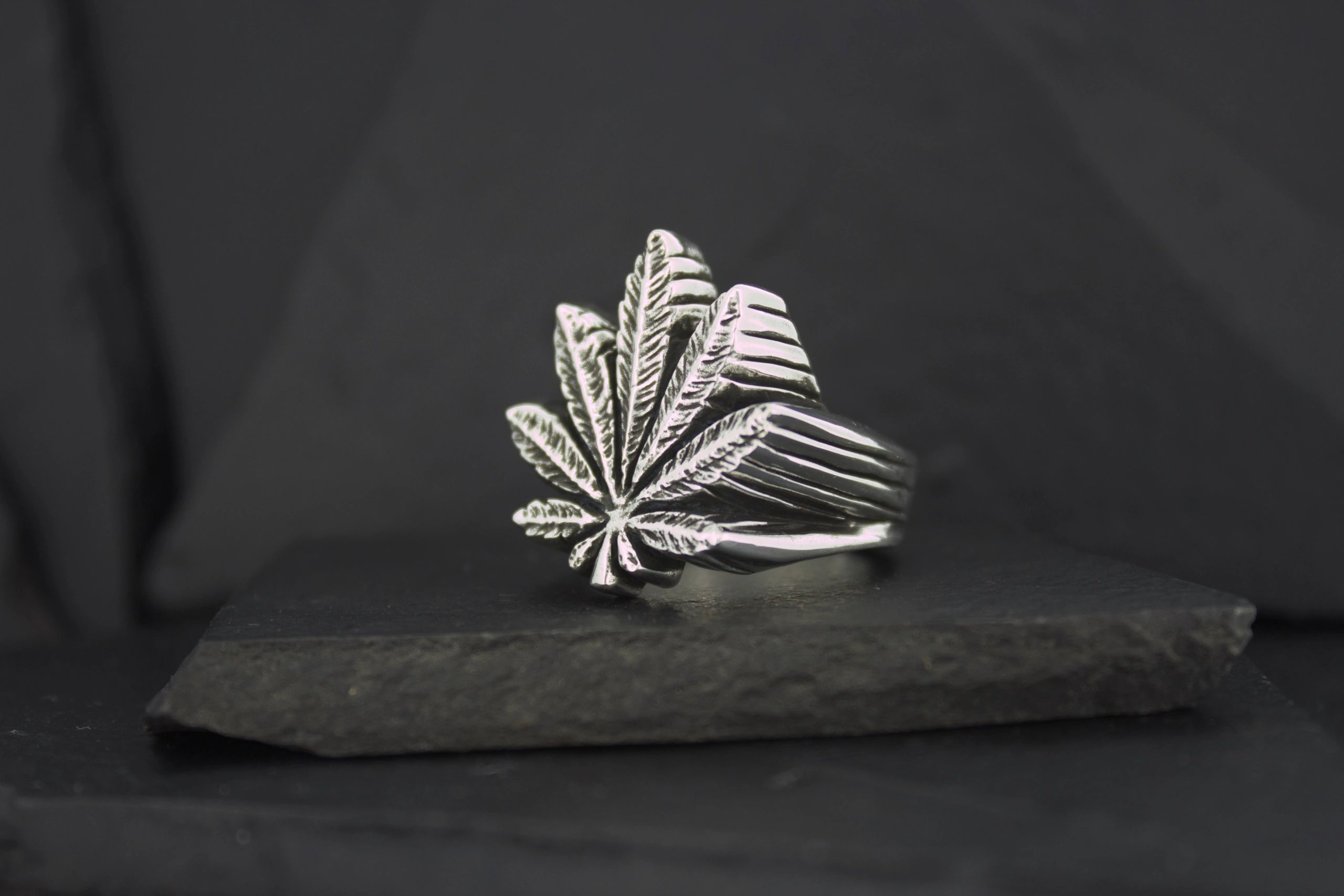 Silver ring shaped like a leaf with intricate details.