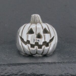 A small silver pumpkin with carved jack-o'-lantern face.