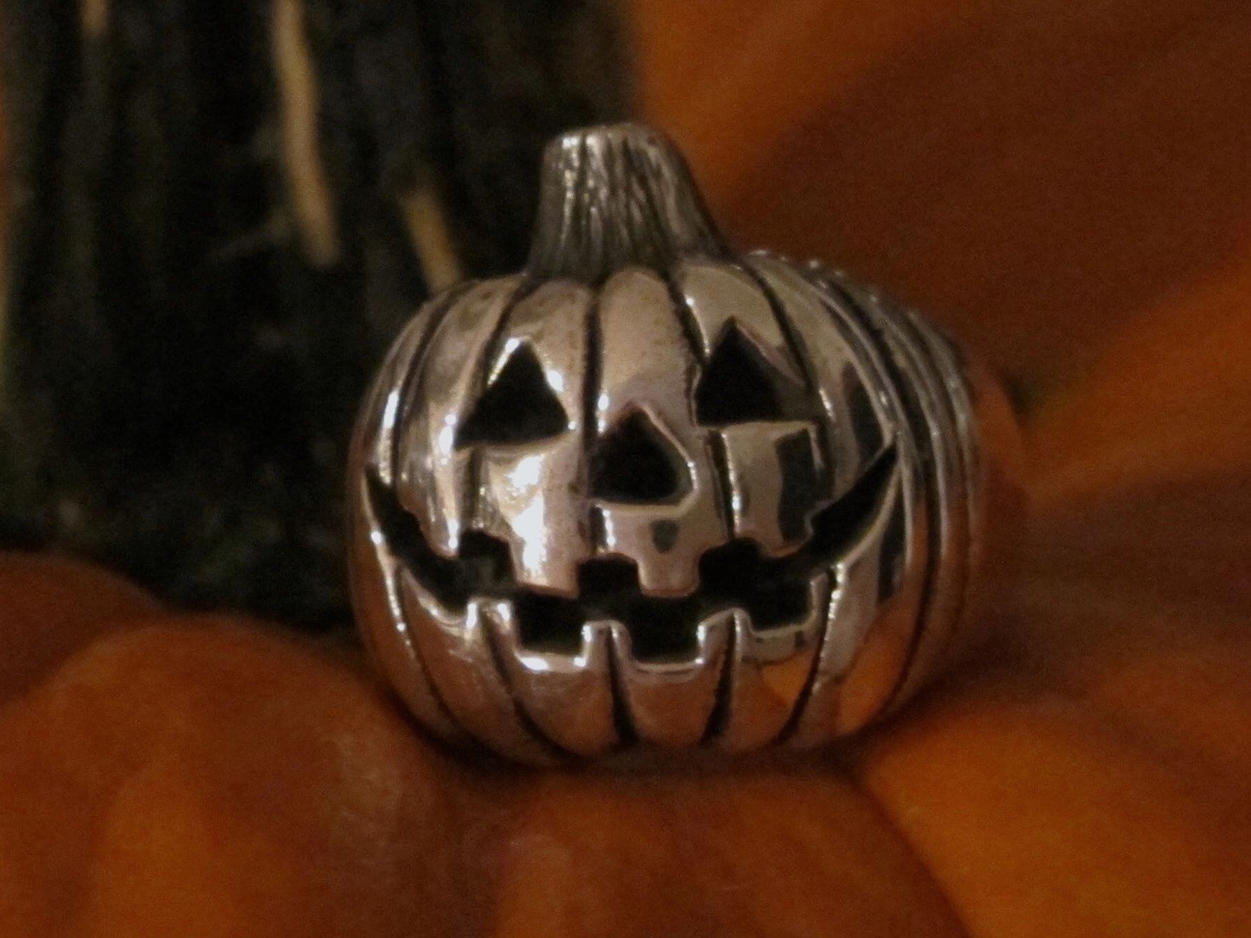A small metal pumpkin with carved facial features.