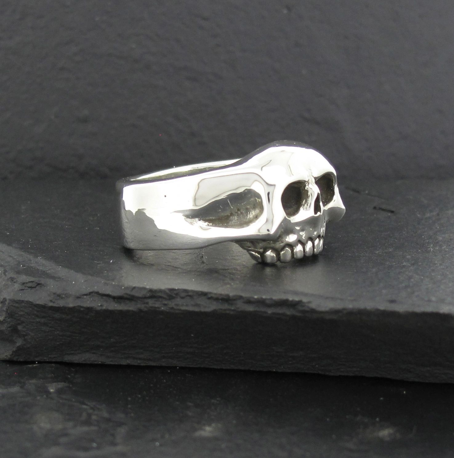 A silver ring featuring a detailed skull design.