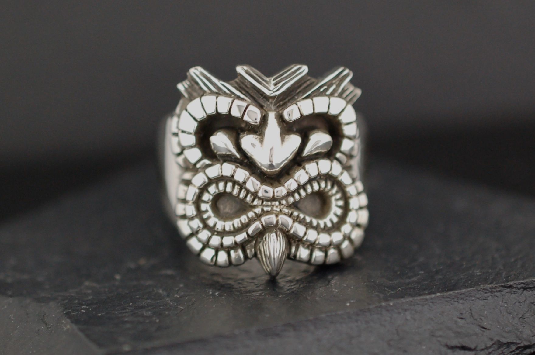 Intricately carved tribal-style ring with a bold design.