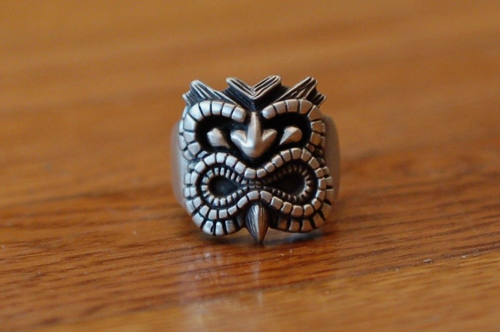 Intricately designed silver ring with a tribal mask motif.