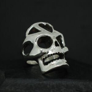 A metallic skull sculpture with hollow eyes and detailed teeth.