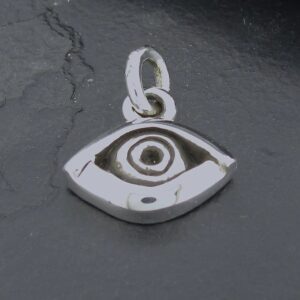A silver eye-shaped pendant on a dark surface.