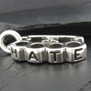 Close-up of a silver pendant spelling 'NATIE'.