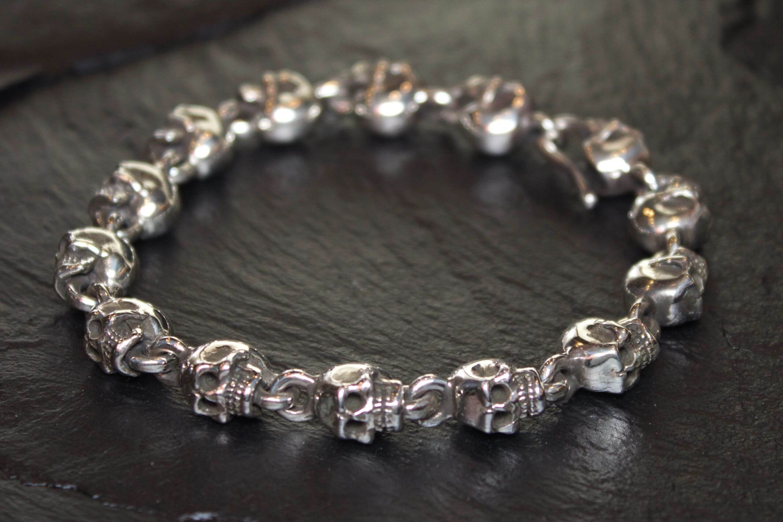 Close-up of a silver skull chain bracelet.