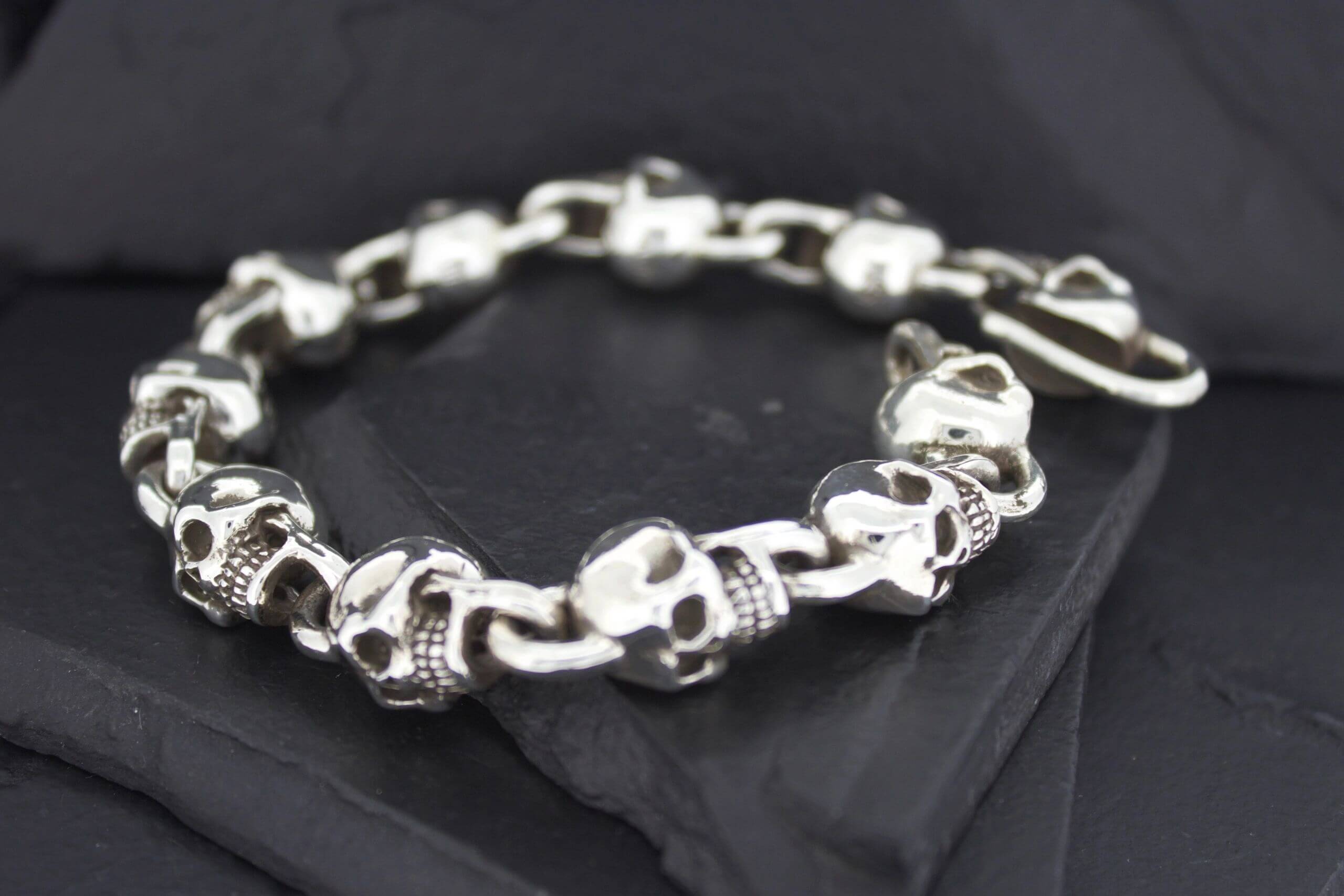 Silver skull and bone bracelet on black fabric.