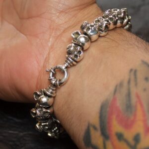 Silver skull bracelet on tattooed wrist.