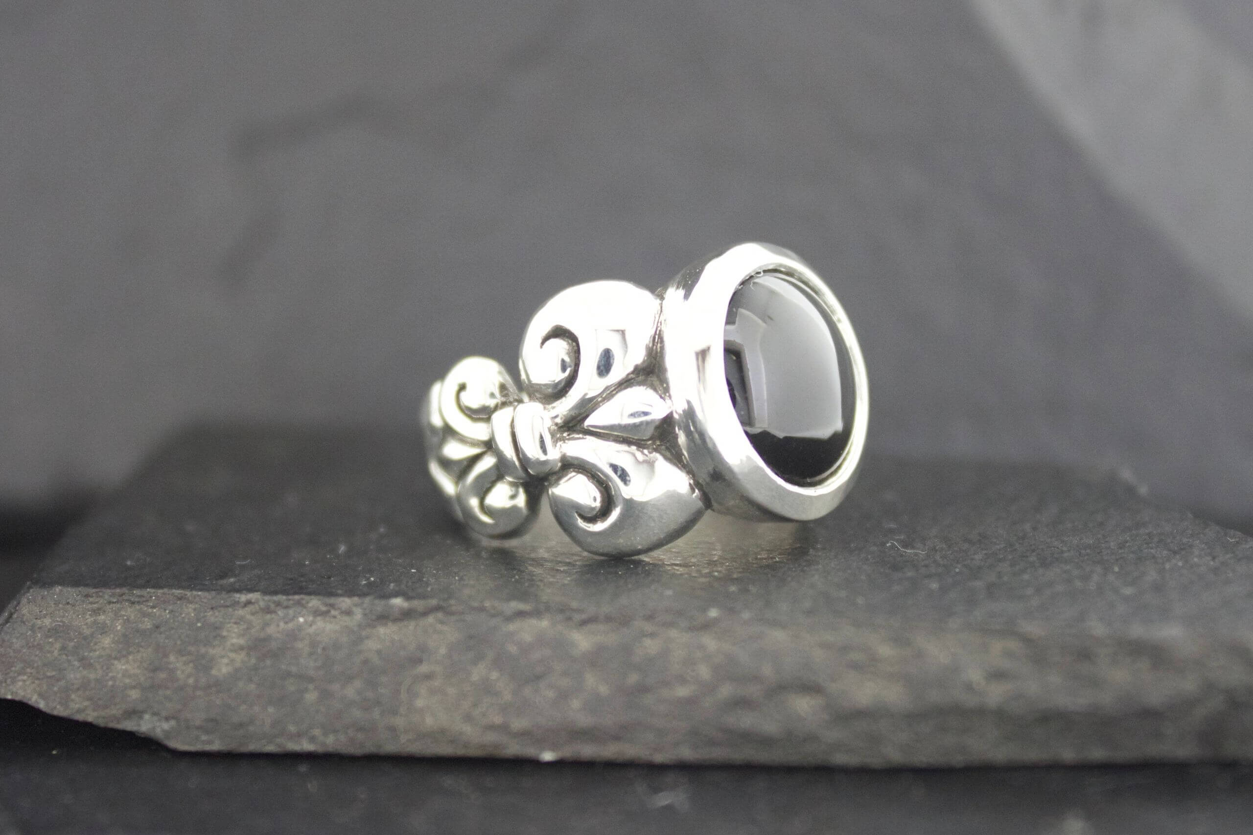Elegant silver ring with black stone and intricate design.