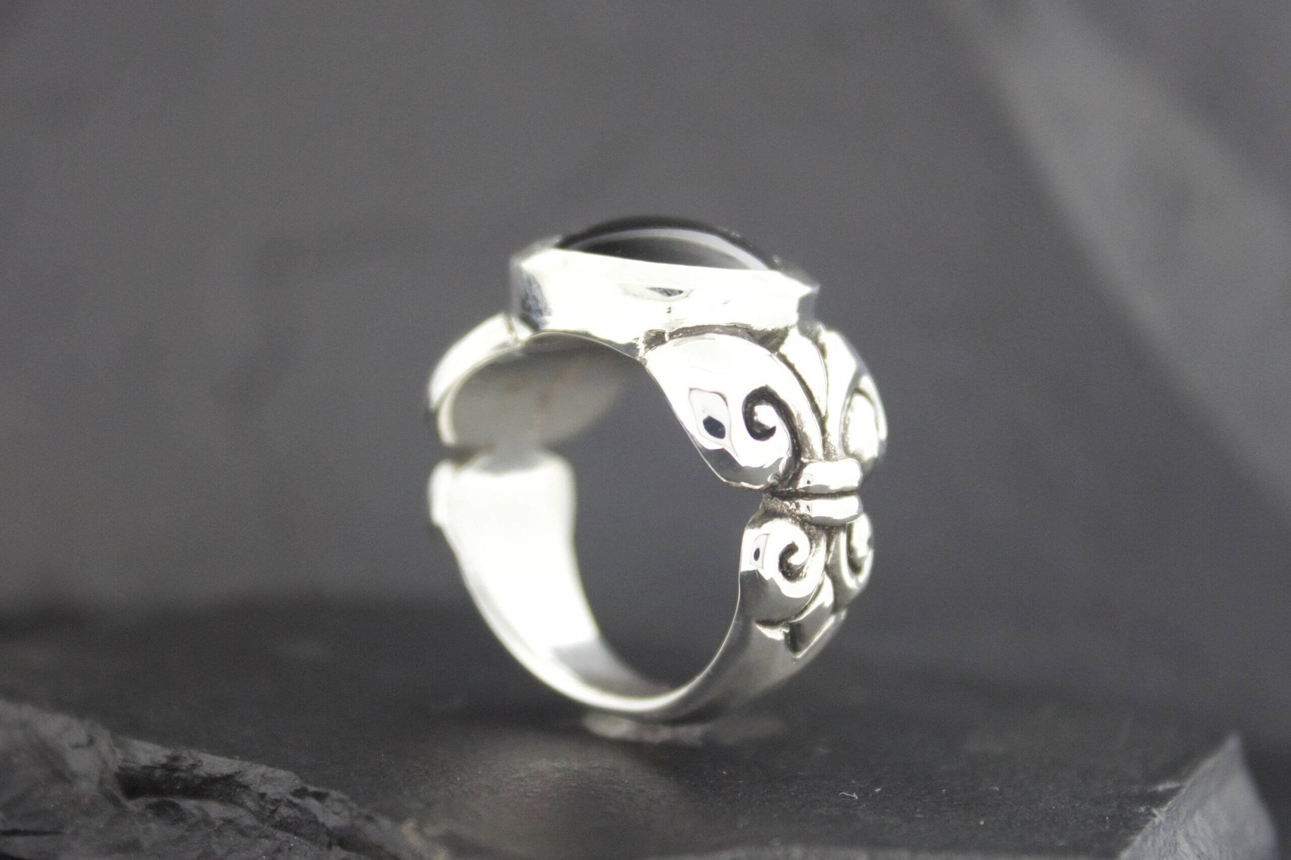 Elegant silver ring with intricate swirled designs.