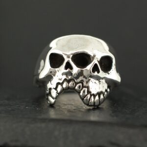 A silver ring designed as a detailed skull with hollow eyes and teeth.