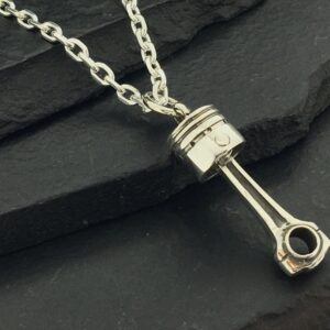 A silver piston-shaped pendant on a chain necklace.
