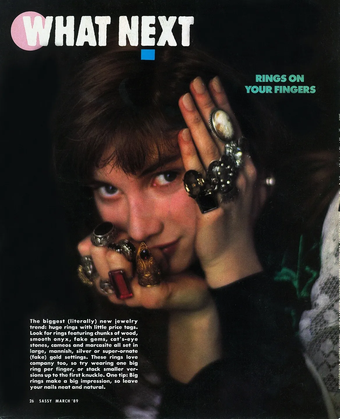 Person with multiple rings posing with hands near face.