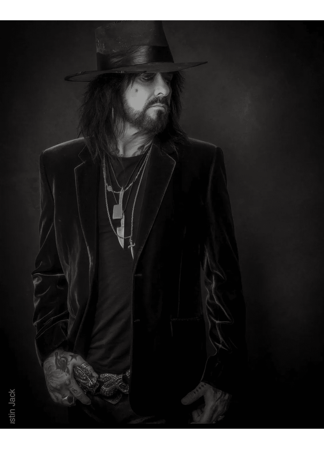 Black and white portrait of a man in a velvet jacket and hat.