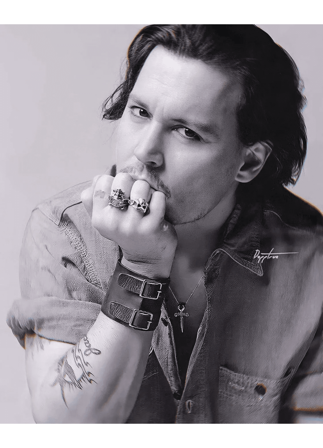 Black-and-white portrait of a contemplative man with rings and bracelets.